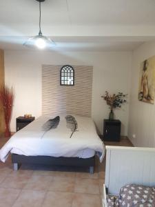 1 dormitorio con 1 cama blanca grande y ventana en gite rural de l ource 