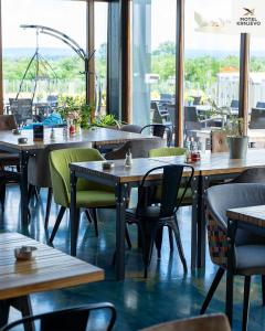 een restaurant met houten tafels, stoelen en ramen bij Motel Krnjevo in Krnjevo