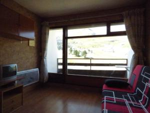 a living room with a large window and a tv at Studio Arette, 1 pièce, 4 personnes - FR-1-602-75 in Arette