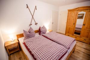 um quarto com uma cama com um cobertor xadrez vermelho e branco em Apartment Almglück em Ehrwald