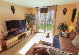 a living room with a couch and a flat screen tv at Bel appartement avec parking souterrain sur place in Martigny-Ville