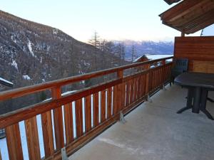 a balcony with a picnic table and a snow covered mountain at Appartement Les Orres, 4 pièces, 8 personnes - FR-1-322-417 in Les Orres