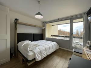 a bedroom with a bed and a large window at Appartement Montgenèvre, 1 pièce, 4 personnes - FR-1-330D-129 in Montgenèvre