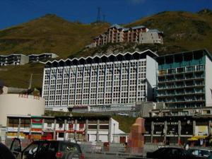 a large white building with a mountain in the background at Studio cabine 4 pers. La Mongie, centre station, près des pistes - FR-1-404-333 in La Mongie +3 photos