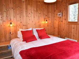 a bedroom with a large bed with red pillows at Chalet Montgenèvre, 5 pièces, 10 personnes - FR-1-266-179 in Montgenèvre