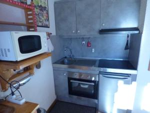 a small kitchen with a microwave and a stove at Studio Saint-Jean-de-Sixt, 1 pièce, 4 personnes - FR-1-458-152 in Saint-Jean-de-Sixt