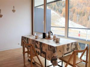 a dining room table with chairs and a large window at Appartement Vars, 1 pièce, 4 personnes - FR-1-330B-189 in Vars