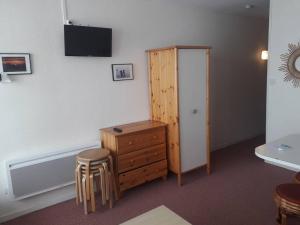 a room with a dresser and a wooden cabinet and stool at Studio 4 pers avec balcon sur les pistes, parking gratuit, casier à skis et kitchenette aménagée - FR-1-602-32 in Arette