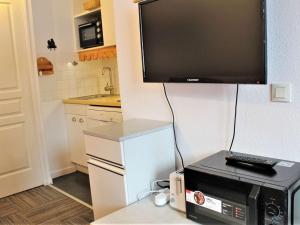 eine Küche mit einer Mikrowelle und einem TV an der Wand in der Unterkunft Appartement Risoul, 2 pièces, 6 personnes - FR-1-330-544 in Risoul