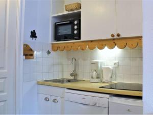 eine Küche mit einer Spüle und einer Mikrowelle in der Unterkunft Appartement Risoul, 2 pièces, 6 personnes - FR-1-330-544 in Risoul