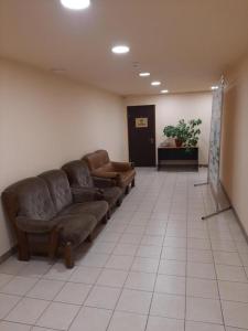 una sala de espera con sofás de cuero en una habitación en Hotel Pivdennyi, en Oleksandriya