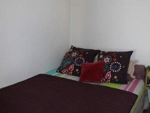 a bed with colorful pillows on it in a room at Appartement Ajaccio, 1 pièce, 2 personnes - FR-1-61-473 in Ajaccio