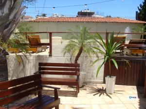 2 bancos de madera sentados en un patio con palmeras en São Roque Park Hotel, en São Roque
