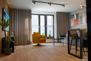 a living room with a yellow chair and a table at HALO Apartament 07 in Wrocław