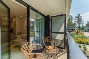 a room with a balcony with chairs and a couch at MARE SHELLTER ROGOWO koło Kołobrzegu in Rogowo