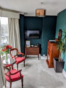 sala de estar con mesa, sillas y paredes azules en The Franklin, en Harrogate