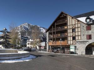 a building on a street in front of a mountain at Duplex 10 pers à Saint-Lary-Soulan avec jacuzzi et sauna - FR-1-296-340 in Saint-Lary-Soulan