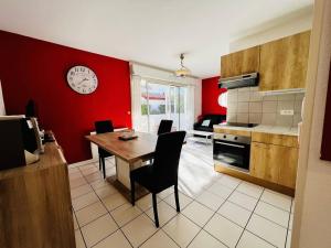 eine Küche mit einem Tisch und einer Uhr an der Wand in der Unterkunft Appartement Cambo-les-Bains, 2 pièces, 2 personnes - FR-1-495-102 in Cambo-les-Bains