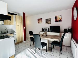 eine Küche mit einem Esstisch und Stühlen in der Unterkunft Appartement Cambo-les-Bains, 2 pièces, 2 personnes - FR-1-495-102 in Cambo-les-Bains