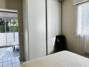 1 dormitorio con 1 cama y puerta corredera de cristal en Appartement Cambo-les-Bains, 2 pièces, 2 personnes - FR-1-495-102, en Cambo-les-Bains