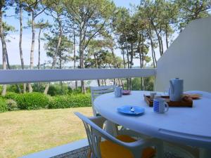 een blauwe tafel en stoelen op een balkon met bomen bij Appartement La Trinité-sur-Mer, 3 pièces, 4 personnes - FR-1-477-191 in La Trinité-sur-Mer