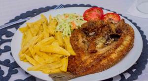 a plate of food with french fries and meat at Avon Garden Lodge in Salima