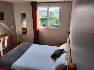 1 dormitorio con cama y ventana en Hotel Au Bout Du Monde, en Le Conquet