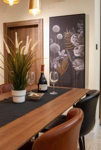 tavolo da pranzo con bicchieri da vino e una pianta di N10 Apartment a Belgrado