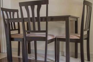 einen Holztisch und zwei Stühle nebeneinander in der Unterkunft Avon Garden Lodge in Salima
