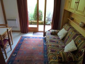 a living room with a couch in front of a door at Appartement Saint-Jean-d'Aulps, 2 pièces, 4 personnes - FR-1-573-35 in Saint-Jean-d'Aulps