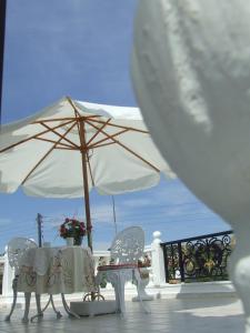 a table and chairs with an umbrella on a deck at Castellino Studios in Faliraki