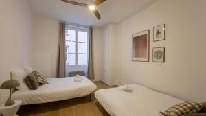 1 dormitorio con 2 camas y ventana en NOCNOC - Le Rayonnant en Lyon