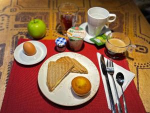 einen Tisch mit einem Teller Toast, einem Apfel und Eiern in der Unterkunft Design Hotel 36 in Sofia