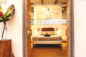 1 dormitorio con 1 cama con dosel en Villa Laurel - Comfort with Beautiful Jungle View en Puerto Viejo