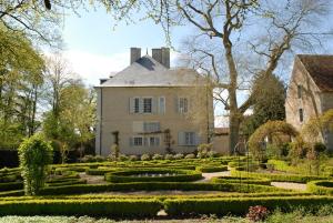 uma casa grande com um jardim em frente em Les Rossignols em Saint-Jeanvrin