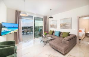 uma sala de estar com um sofá e uma televisão em Costa Maris Villa em Georgioupoli