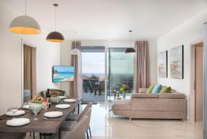 Costa Maris Villa في Georgioupoli: غرفة معيشة مع طاولة وأريكة