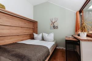 1 dormitorio con 1 cama con cabecero de madera en CozyStay - Gemütliche Wohnung im Oberharz, en Sankt Andreasberg