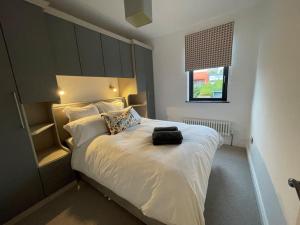 ein Schlafzimmer mit einem weißen Bett mit einem großen Kopfteil in der Unterkunft Cheerful 2 bed house on Causeway Coastal Route with parking in Whiteabbey