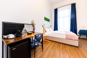 um quarto de hotel com uma cama e uma secretária num quarto em Adagio Downtown Rooms em Budapeste