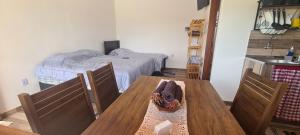 a dining room with a table and a bed at Pousada Colina das Maritacas in São Thomé das Letras +21 photos