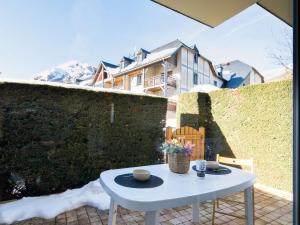 a white table sitting on a patio in front of a wall at Confort et Accès Facile : Proche Télécabine, 2 Chambres - FR-1-296-364 in Saint-Lary-Soulan