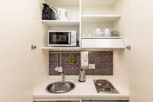 a small kitchen with a sink and a microwave at Vittoria Charme in Rome