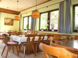 a dining room with a table and chairs and windows at Landgasthaus Lehnerwirt in Alkoven +8 photos