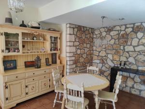 a kitchen with a table and a stone wall at Alkyon Villas in Syvota