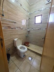 een kleine badkamer met een toilet en een douche bij العاصم للشقق الفندقية ALASEM HOTEL APARTMENTS in Aqaba