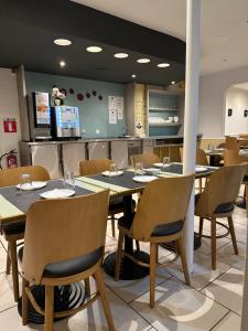 a dining room with a table and chairs at Hôtel de Lyon in Valence