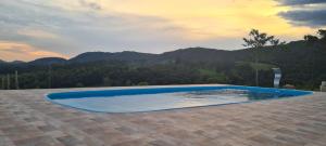 a swimming pool with a view of the mountains at Pousada Colina das Maritacas in São Thomé das Letras