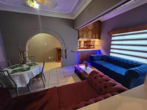 a living room with a table and a blue couch at La-Nuel Guest Lodge in Boksburg