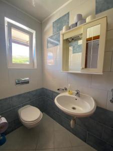 a bathroom with a toilet and a sink at Apartman "Niko" in Povile